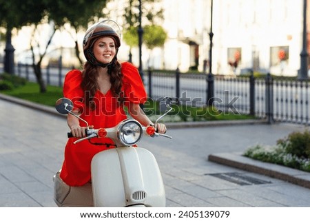 Young woman in helmet riding on motorbike moped scooter in city street Royalty-Free Stock Photo #2405139079