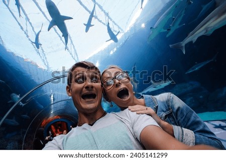 Happy couple taking selfie in shark glass tunnel in Aquarium.