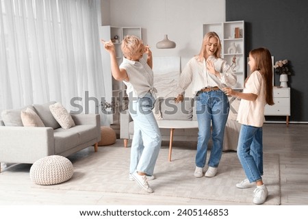 Little girl with her mom and grandmother dancing at home