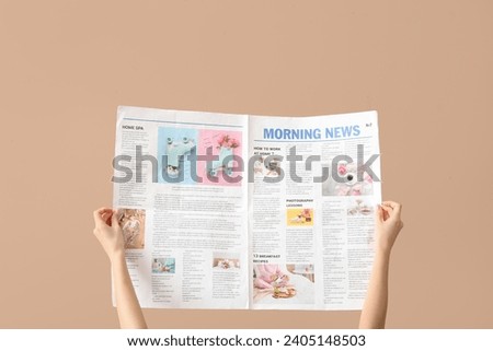 Woman with newspaper on beige background