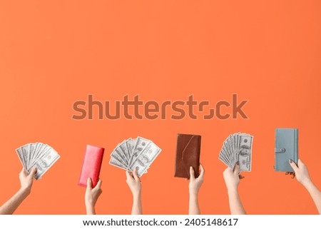 Women with dollar banknotes and wallets on orange background