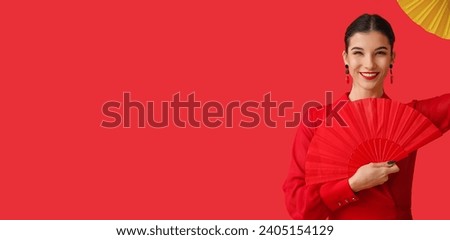 Beautiful young woman with fans on red background with space for text. Chinese New Year celebration