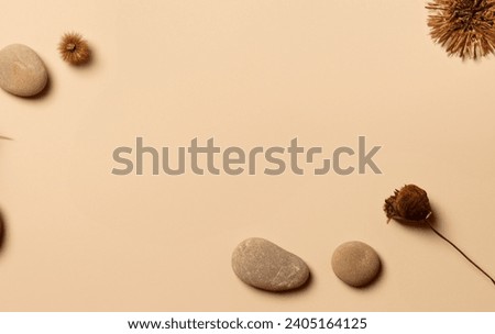 Abstract nature scene composition of stones and dry flower decoration above pastel beige table background . Minimalist product branding, identity and packaging Copy space in center, 