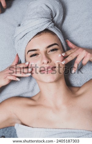 Young girl with perfect skin on a white background, towel on her head, beauty concept photo, skin care, spa concept, treatment, facial massage.