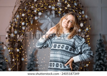 A girl's New Year's photo shoot. a girl in a New Year's sweater on the background of a decorative arch. individual photo shoot in one woman's photo studio