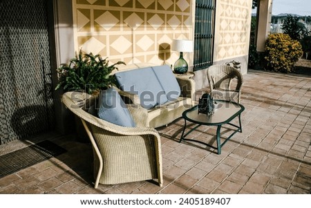 Dining coffee table with chairs on tile floor exterior. Living area in countryside house or hotel. Beautiful urban architectural photography. 