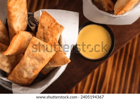 Fried tequenos stuffed with cheese and dipping sauce