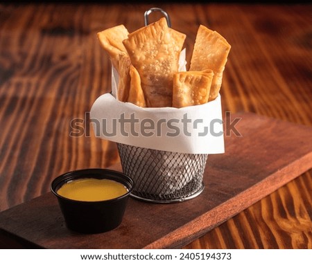 Fried tequenos stuffed with cheese and dipping sauce