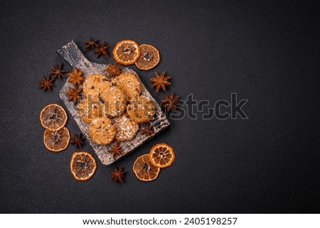 Delicious sweet round sponge cookies sprinkled with coconut flakes on a dark concrete background