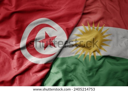 big waving national colorful flag of kurdistan and national flag of tunisia . macro