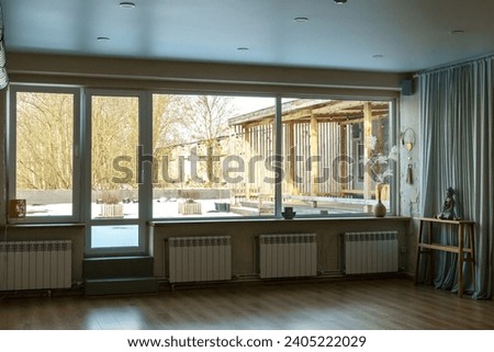 A spacious hall with large windows and radiators. Panoramic windows made of fiberglass in the fitness room. Interior and design ideas. Royalty-Free Stock Photo #2405222029