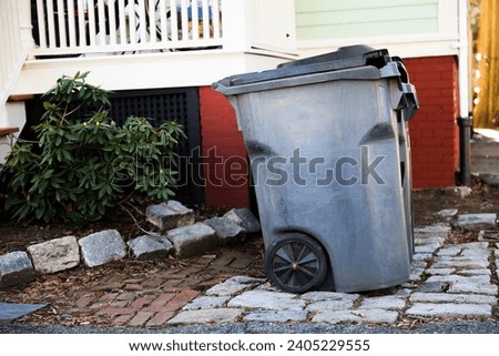Trashcan in urban setting, symbolizing waste disposal and environmental impact. Conceptual stock photo