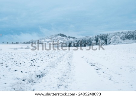 Winter snowy landscape with blue beautiful sky.Snowy mountain and forest under snowy blue clouds. Winter weather.Winter frosty wallpaper. Winter nature. Natural beautiful texture.  Royalty-Free Stock Photo #2405248093