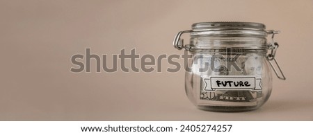 Saving Money In Glass Jar filled with Dollars banknotes. FUTURE transcription in front of jar. Managing personal finances extra income for future insecurity