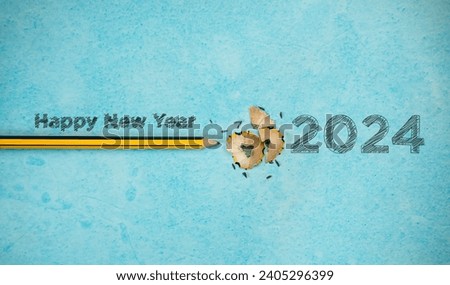Creative 2024 New Year background, Happy New Year written with pencil on a blue paper