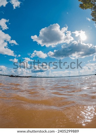 Muddy Amazon River under a blue sky, surrounded by lush greenery in Leticia, Amazonas, Colombia Royalty-Free Stock Photo #2405299889