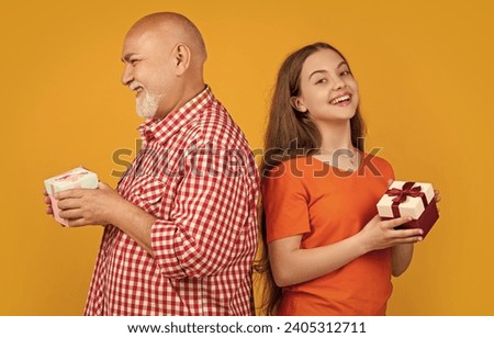 smiling kid and grandfather with present box for anniversary