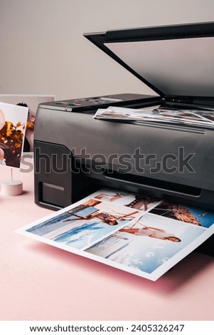 Modern laser printer printing color photos of women close up