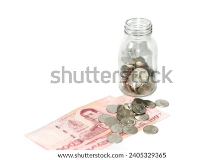 Put the money coins in the bottle and 100 baht banknote on white background with isolated picture.