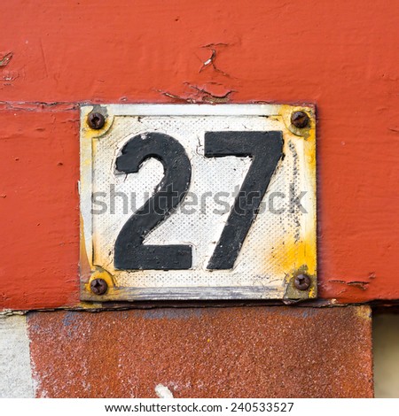 weathered house number twenty seven made of cast aluminum and painted over