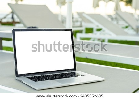 Computer laptop with blank screen near the swimming pool.