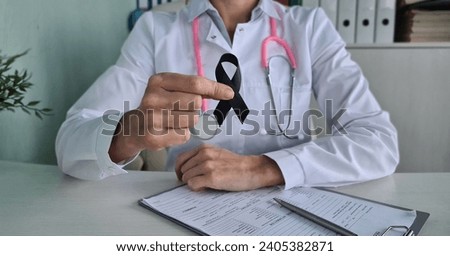 Awareness of black tape in doctor hand for melanoma and skin cancer and narcolepsy. Malignant tumor and developing from melanocytes and pigment cells and moles Royalty-Free Stock Photo #2405382871