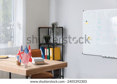 Flags with books and coffee on table in English classroom