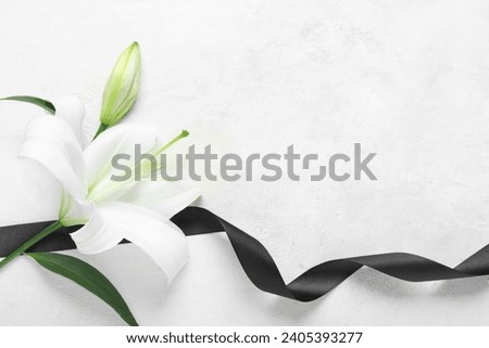 Beautiful lily flowers with funeral ribbon on white background Royalty-Free Stock Photo #2405393277