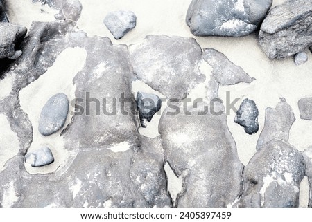 Large grey stones in white sand beach holiday vibes Spain Fuerteventura Canary Islands creative wallpaper texture background