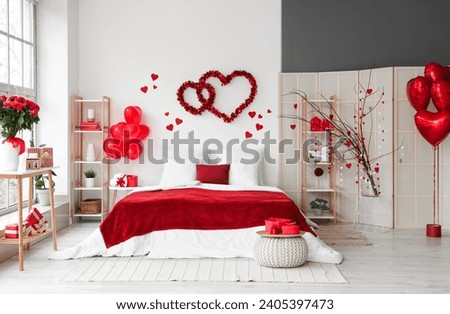 Interior of festive bedroom decorated with hearts for Valentine's Day celebration Royalty-Free Stock Photo #2405397473