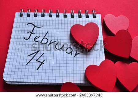 februar 14 write in kalendar between hearts - red valentines day background 