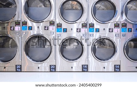 Rows of Vending Washing Machines and Clothes Dryer are opening to service general customers in modern Laundromat Shop Royalty-Free Stock Photo #2405400299