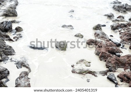 Large grey stones in white sand beach holiday vibes Spain Fuerteventura Canary Islands creative wallpaper grunge texture background nice composition