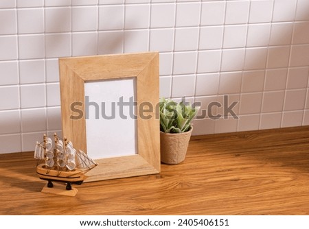 Wooden photo frame, decorative ship and green plant in eco pot. Copy space for text.