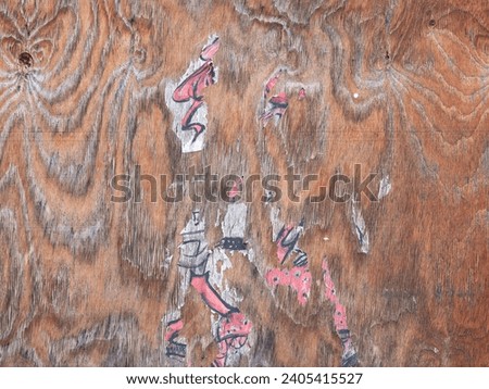 Wooden texture with paper residues from an advertisement placard. The exterior wall is dirty and weathered. Abstract background structure from the material pattern.