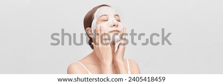 Beautiful young woman with sheet facial mask on color background. panorama Royalty-Free Stock Photo #2405418459
