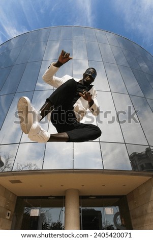 Happy businessman jumping in front of a building