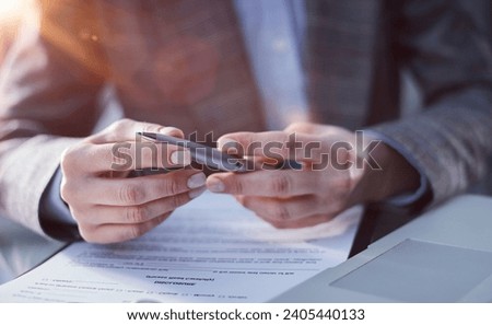 Close-up, a businessman using a stylus signs a document in the office.