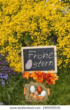 Yellow blooming spring flowers and easter eggs in the nest with a board that reads "Frohe Ostern" which means "happy easter" as easter card concept