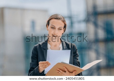 business woman or executive with documents on the street outdoors