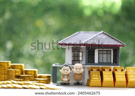 Mutual fund,Love couple senior on gold coin money and gold bar with model house on natural green background, Save money for prepare in future and pension retirement concept Royalty-Free Stock Photo #2405462675