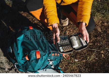 An open first aid kit with medicines, a hiking set of medicines, a minimum set of travel pills, survival in the forest, bushcraft, single adventure. High quality photo Royalty-Free Stock Photo #2405467823