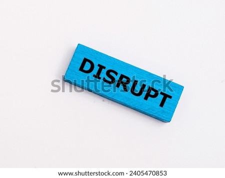 A wooden block with word “DISRUPT” on it