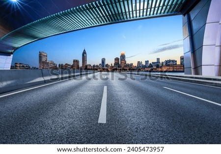 Asphalt road and bridge with modern buildings at dusk in Shanghai