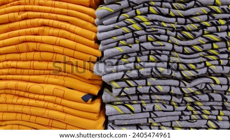 A pile of orange and gray clothes.  In a department store.  Discount clothing.  Cheap and quality.