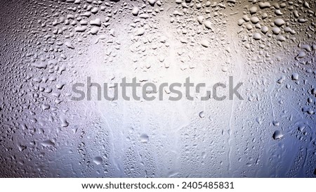 Raindrops on the window. Water drops on glass. Abstract background. Multi-colored spots. Texture of drops. Soft focus
