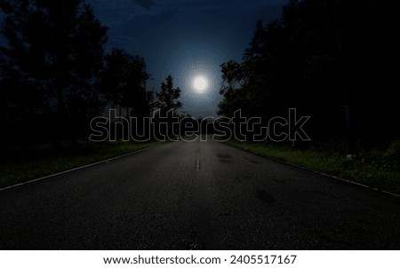 Empty road in forest at night with full moon