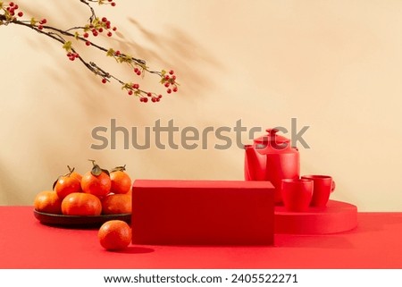 Front view of a red podium placed in the center of the frame, a tea set and a plate of tangerines on the table. Scene for advertising cakes and candy on Tet holiday.
