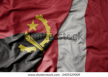 big waving national colorful flag of peru and national flag of angola . macro
