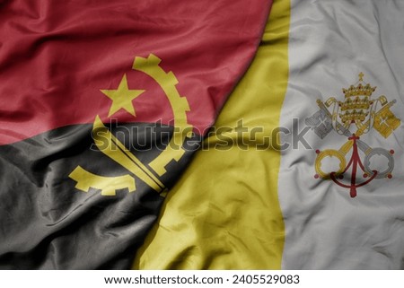 big waving national colorful flag of vatican city and national flag of angola . macro